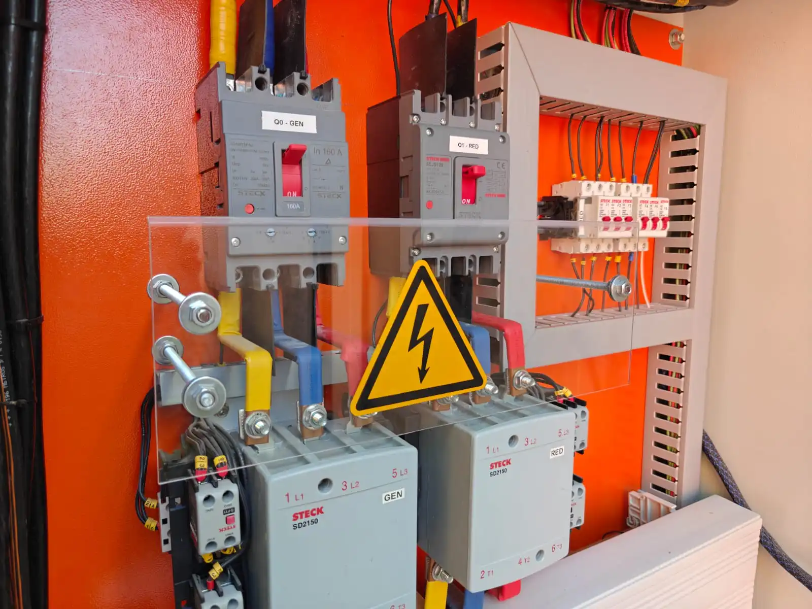 Montaje de contactores y disyuntores con barras de distribución aisladas y protección acrílica en tablero eléctrico industrial por SIEEC