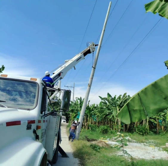 Técnico de SIEEC en camión canasta instalando red eléctrica de media tensión en postes de concreto en Santa Marta, Colombia